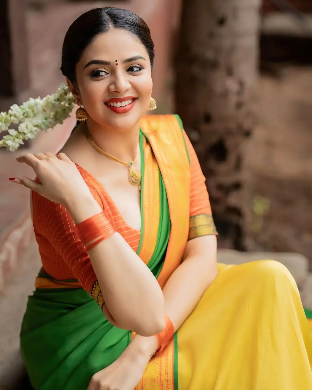 Sreemukhi Stills in Yellow Lehenga Orange Choli Green Voni